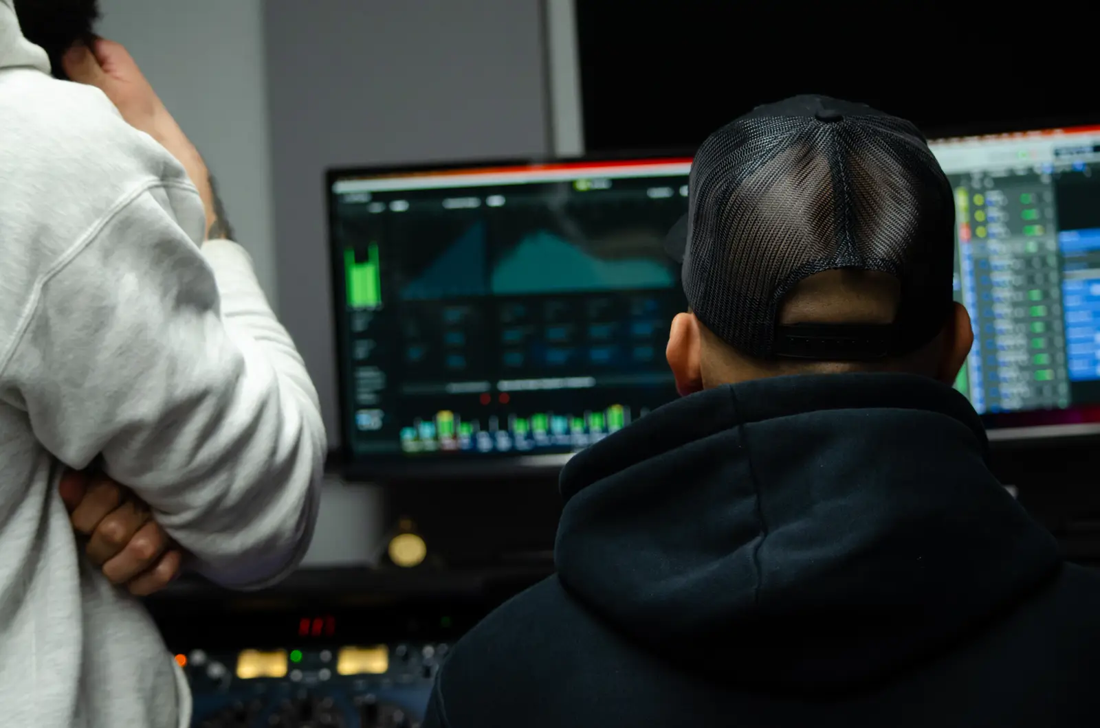 An engineer and artist working together at the 152 ENT production desk.
